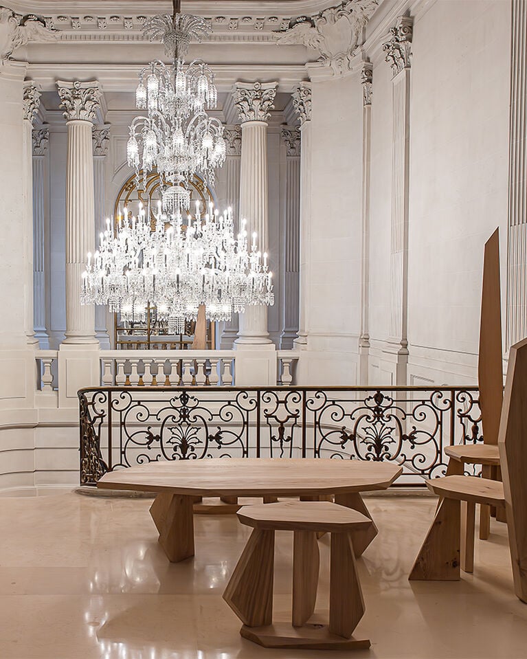 Maison Baccarat first floor with wooden tables, chairs and crystal chandelien